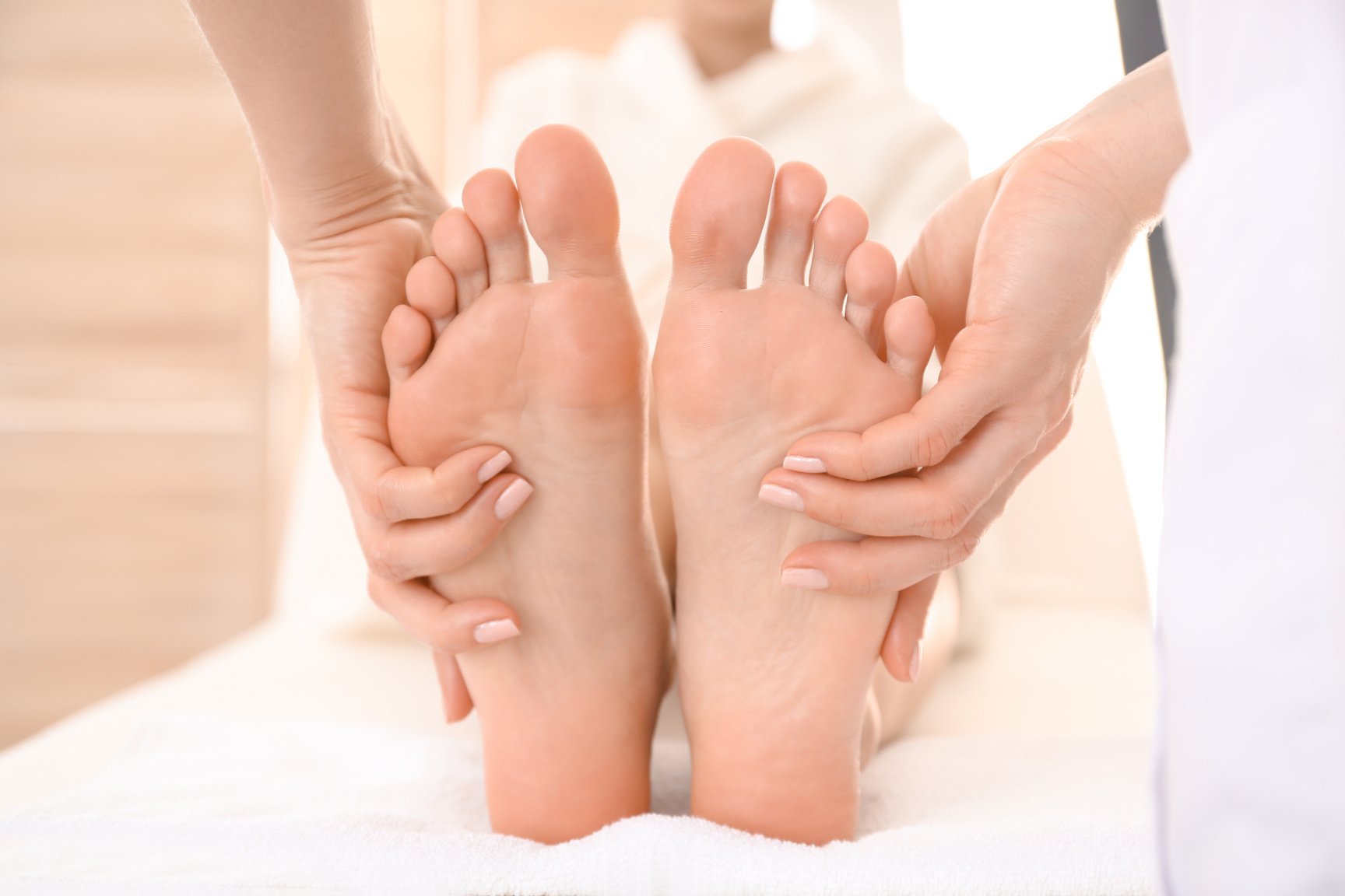 Young Woman Receiving Feet Massage in Spa Salon